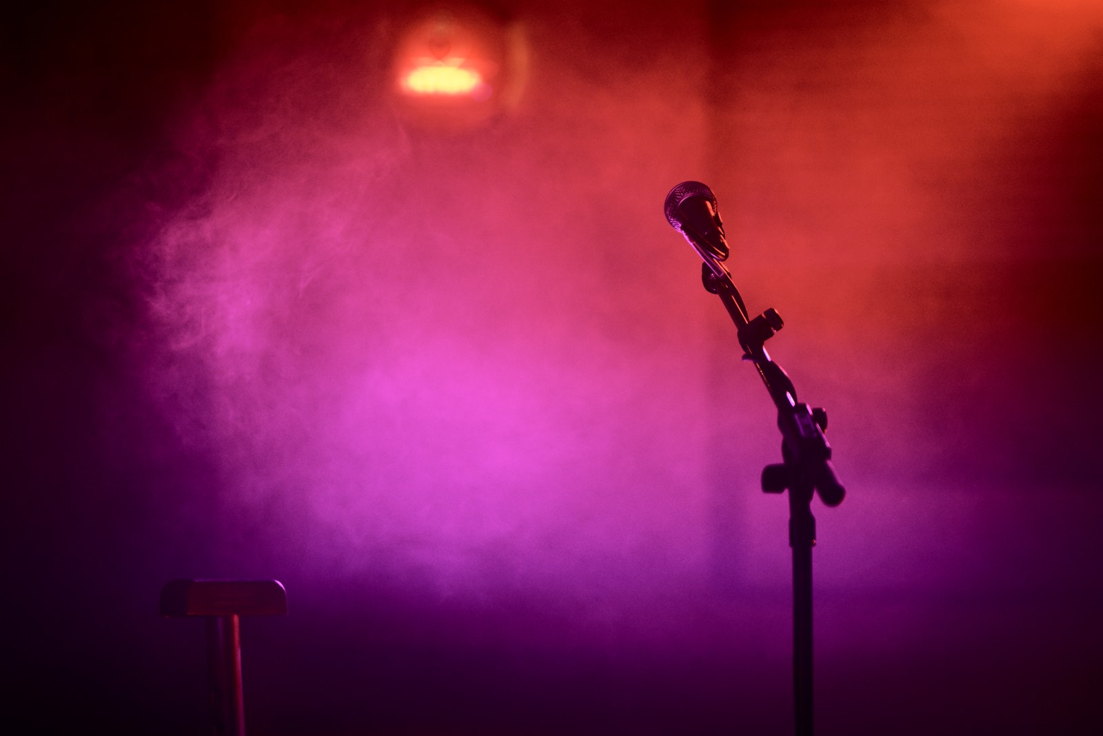 A microphone waits under the stage lights ahead of a stand-up comedy show. (Stock image)